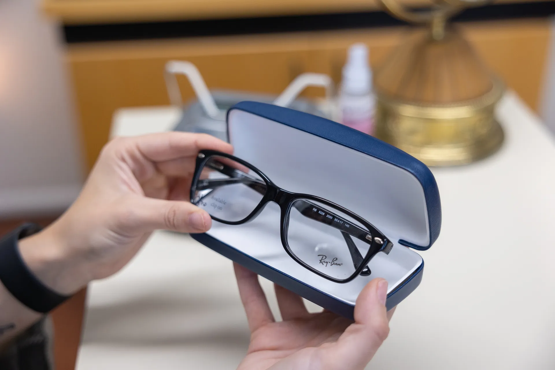 a hand removing a pair of glasses from a case
