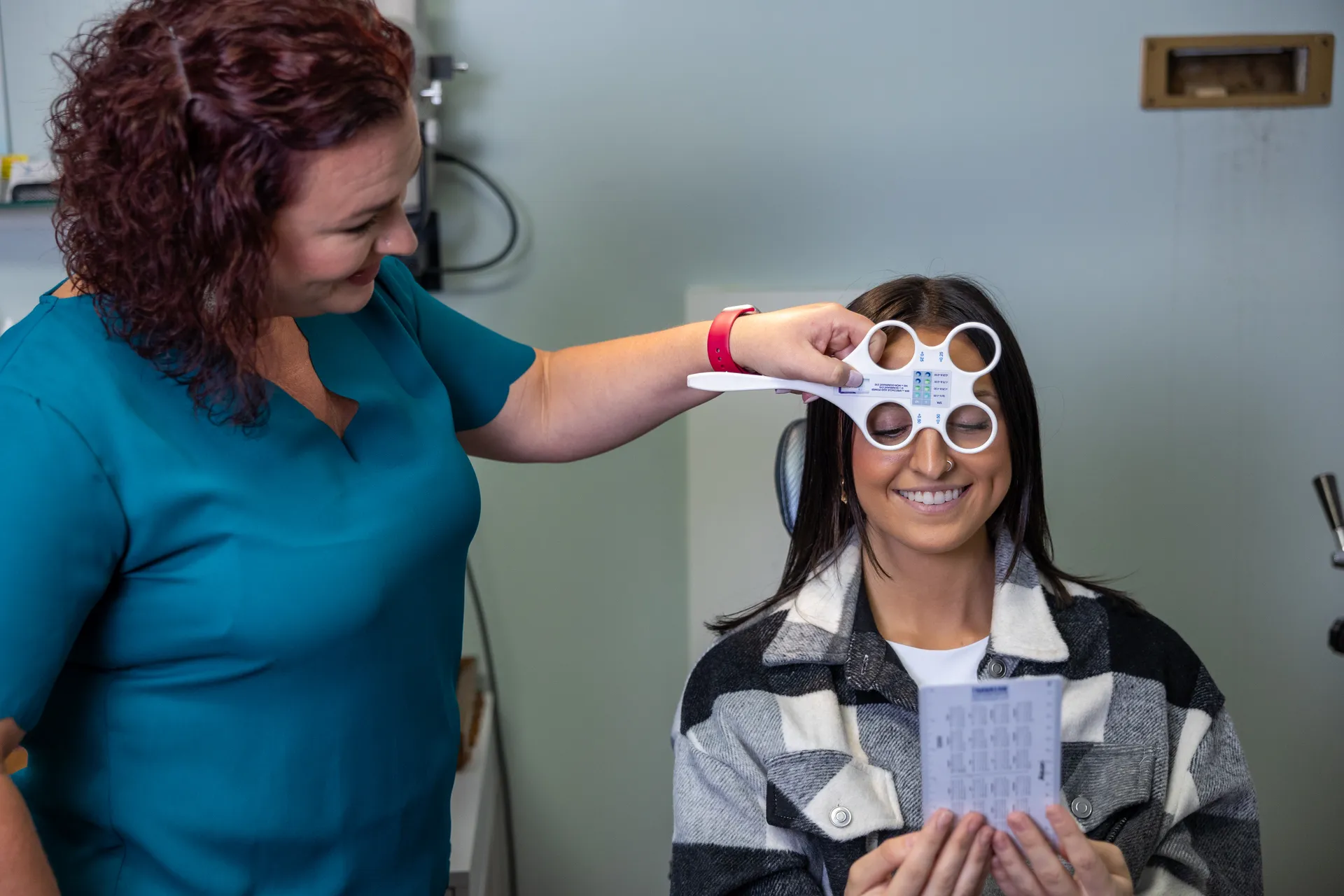 a patient performing an astigmatism test with a physician next to them