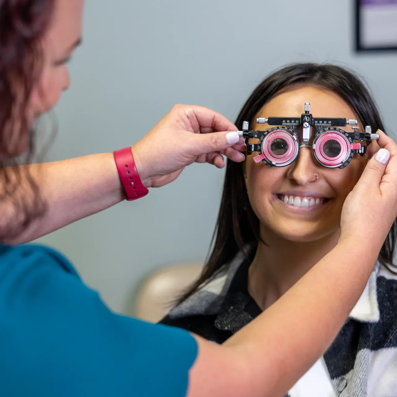 an optometrist examining a patient's eyes while sitting in a chair