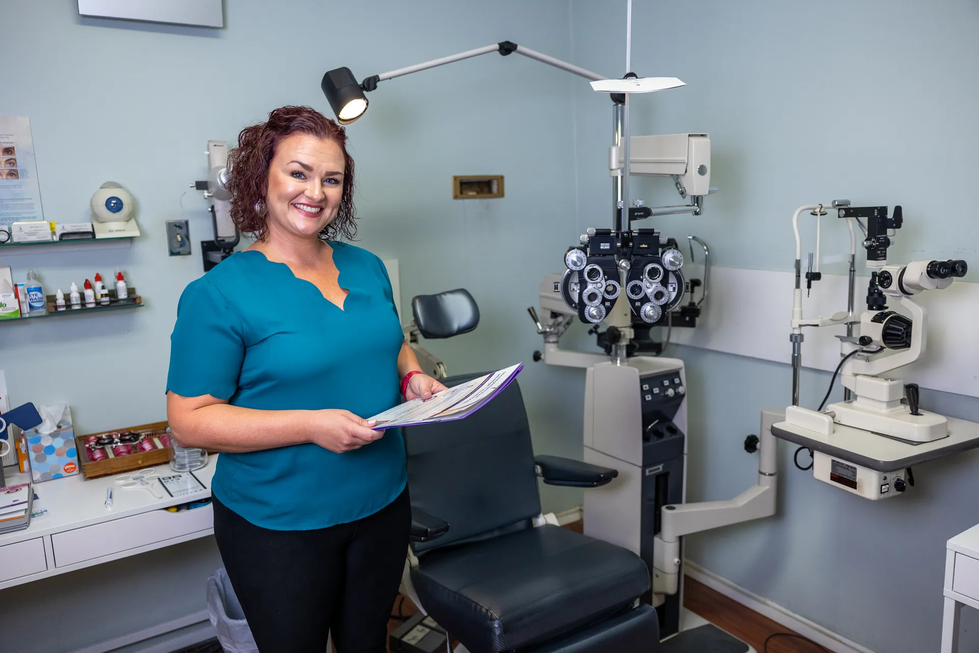 an optometrist standing next to an exam chair