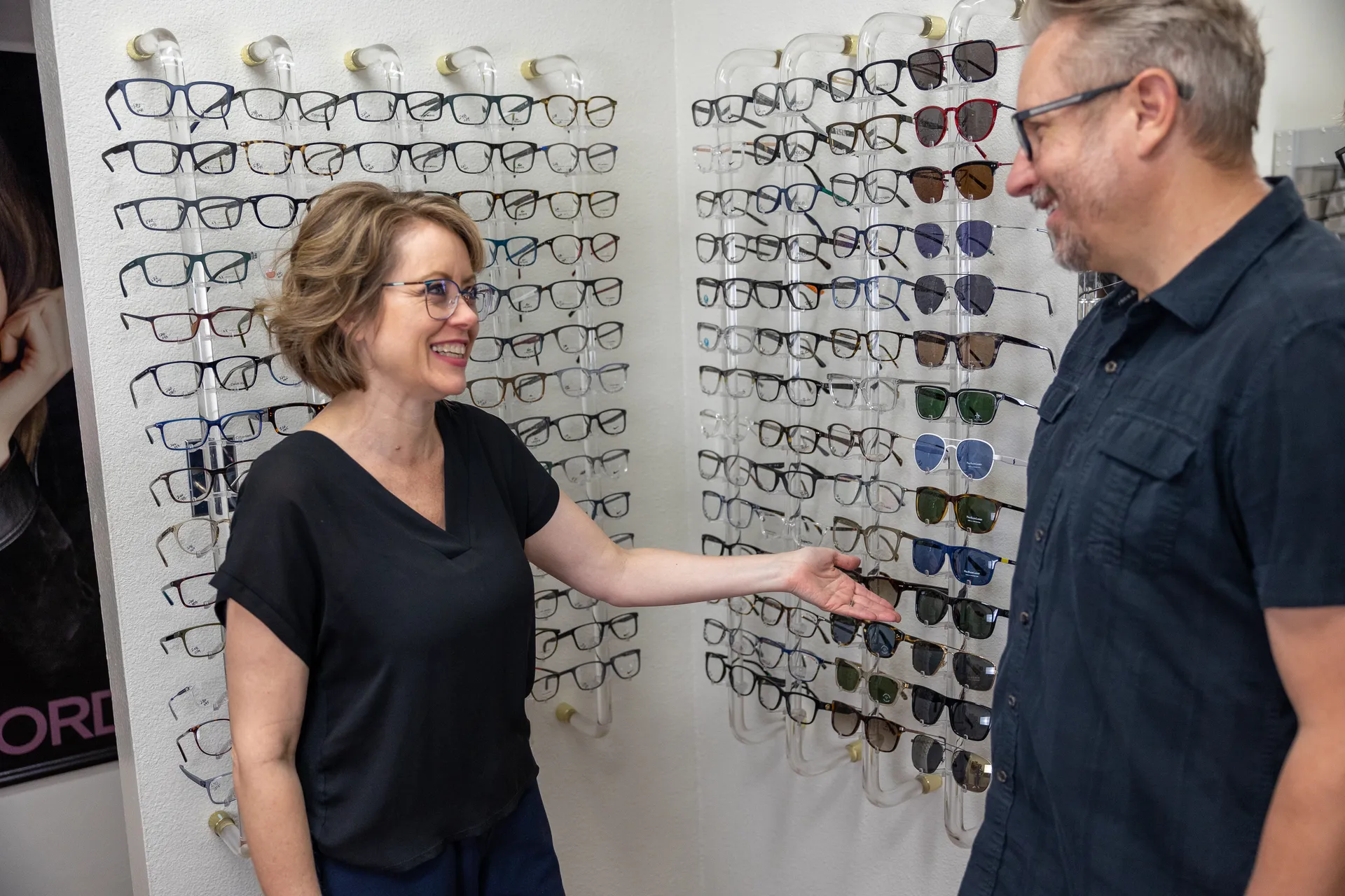 an employee presenting a selection of glasses to a patient