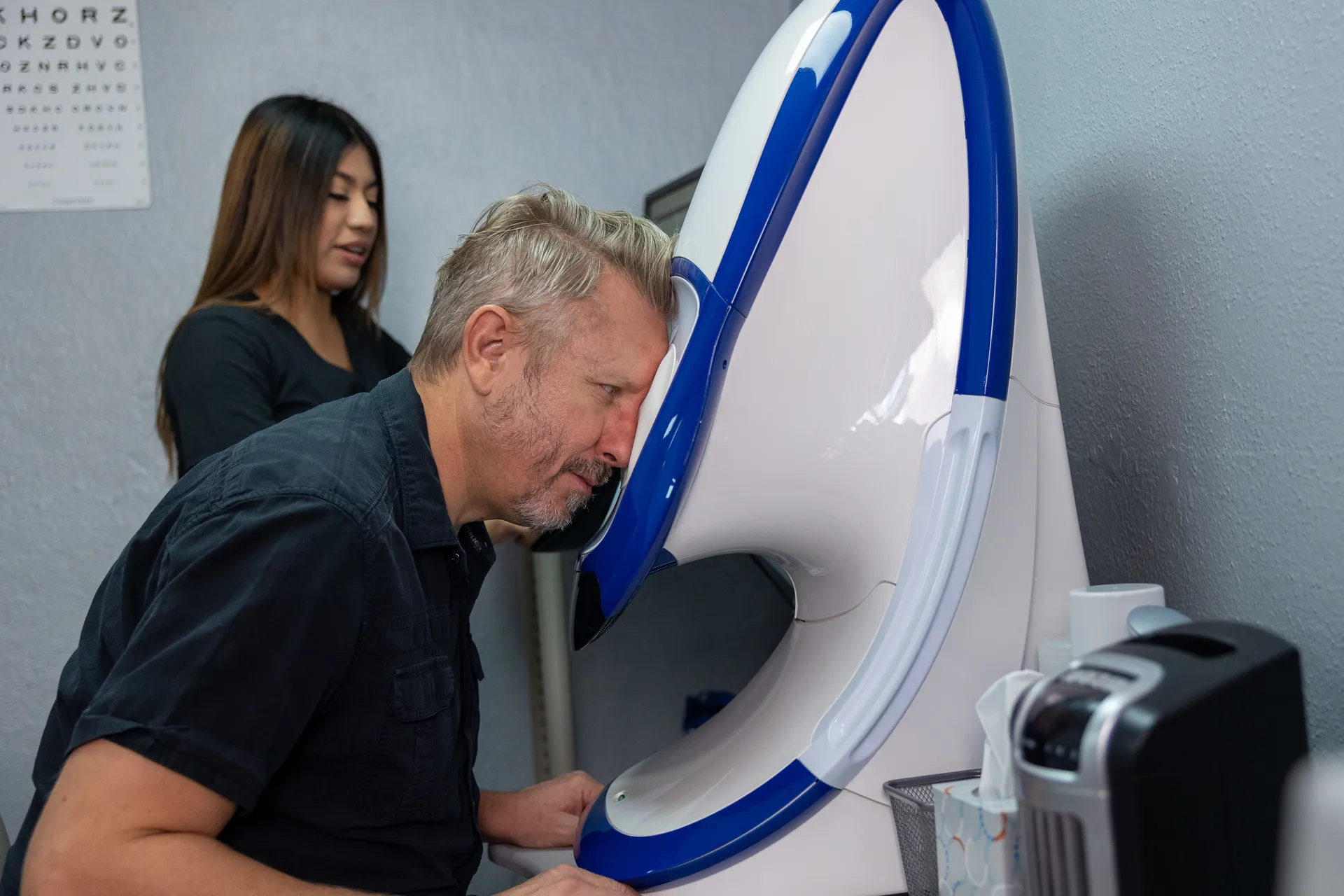 man leaning eye into machine for eye exam