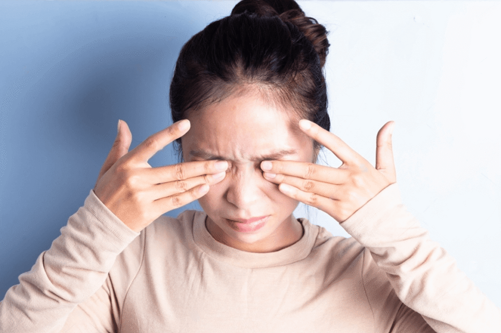 Woman rubbing her eyes from conjunctivitis